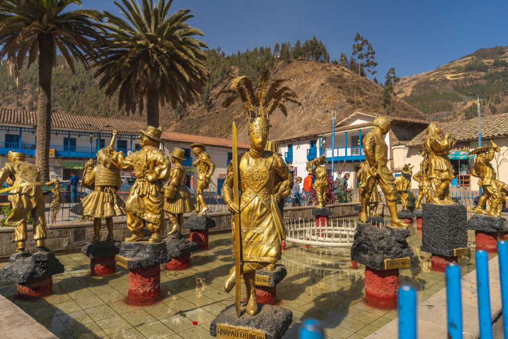 Golden statues of traditional dancers in the main square of Paucartambo
