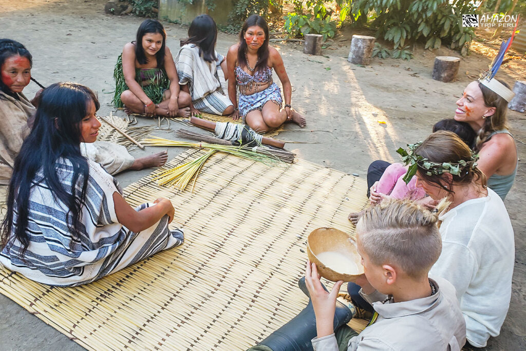 Viajeros compartiendo una bebida tradicional con mujeres de una comunidad nativa